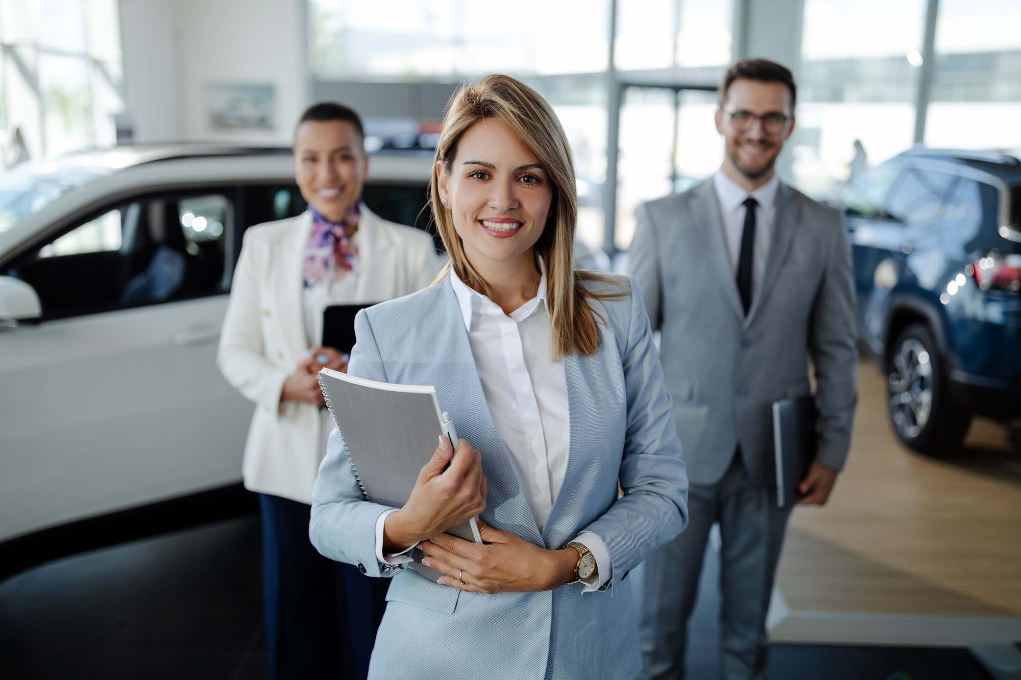 salesteam-in-dealership-three-beautiful-consultants-or-managers-in-elegant-suit-looking-on-camera-.jpg