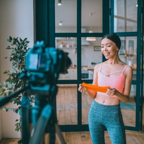 Fitness trainer speaking about resistance bands while filming video